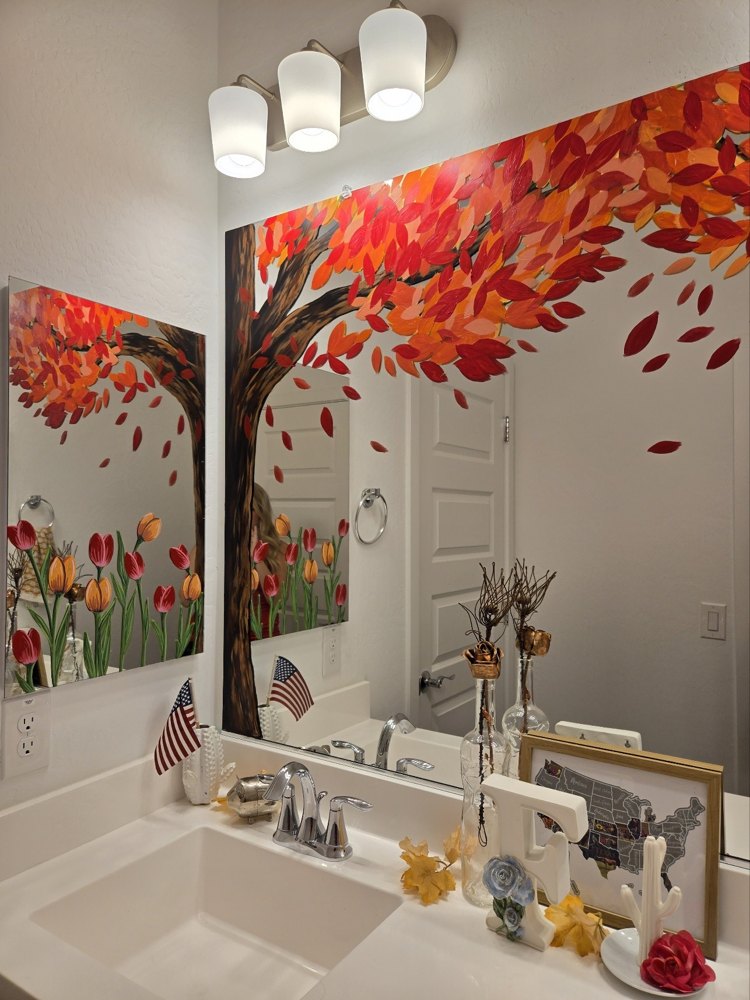 A mirror hand-painted with a tree shedding autumn leaves and tulips
