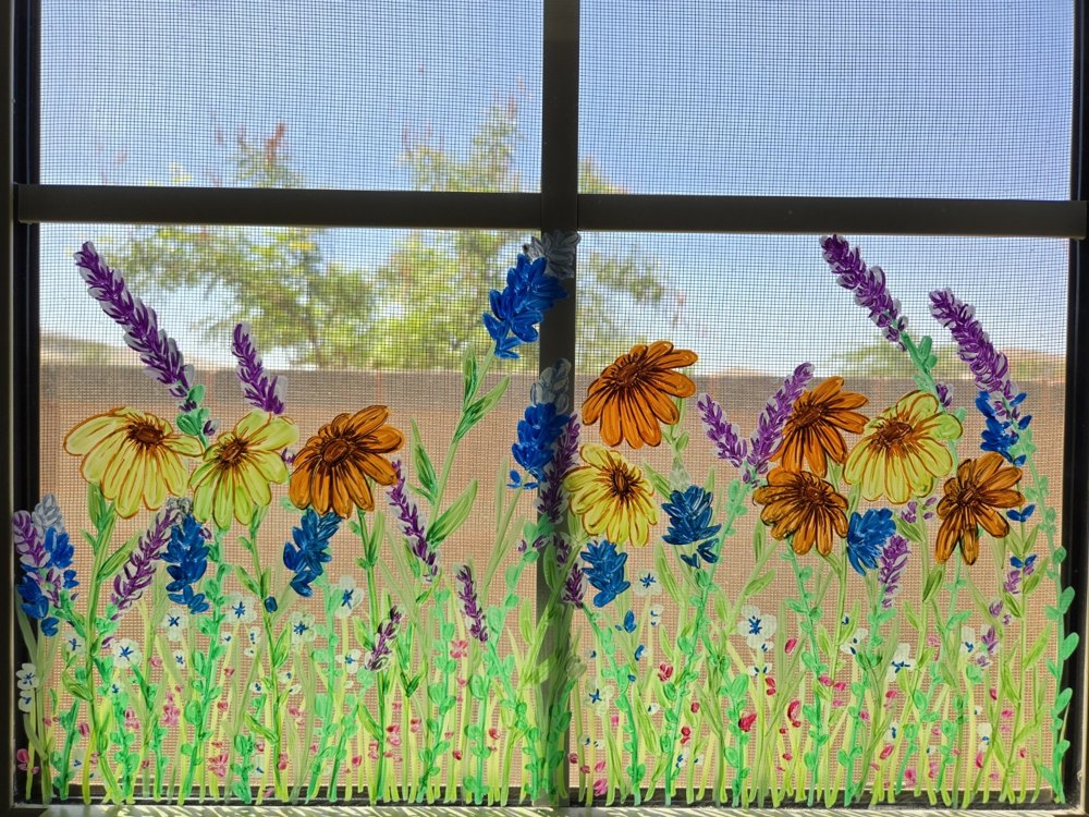 A window hand-painted with sunflowers and wildflowers